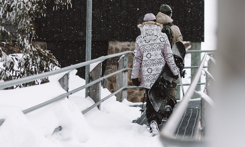 Man and women walking on a snow covered metal bridge