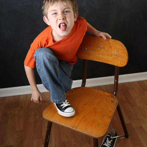 Hyperactive boy with ADHD on a chair