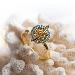 Planet gold spinner ring on a coral