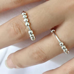 Woman wearing two sterling silver beaded spinner rings