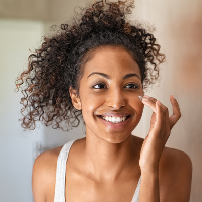 woman applying moisturizer to her face