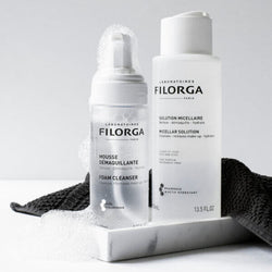 Open FILORGA FOAM CLEANSER and MICELLAR SOLUTION bottles on marble tray with face cloth