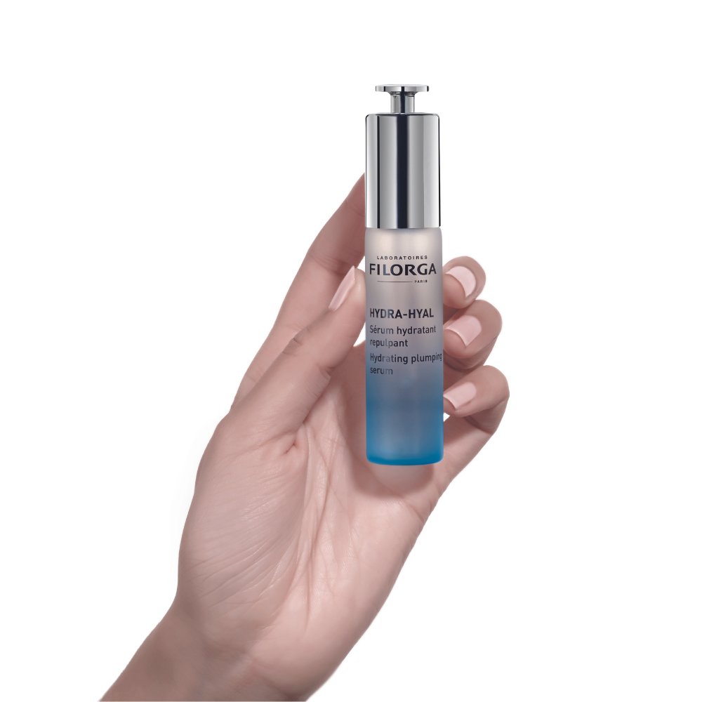 Hand holding closed bottle of FILORGA HYDRA-HYAL SERUM