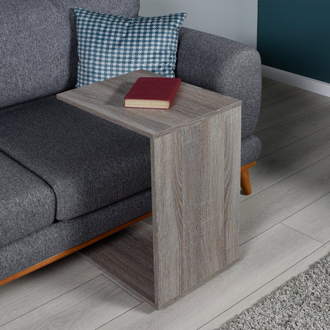 c shaped side table and sofa in living room with a red book