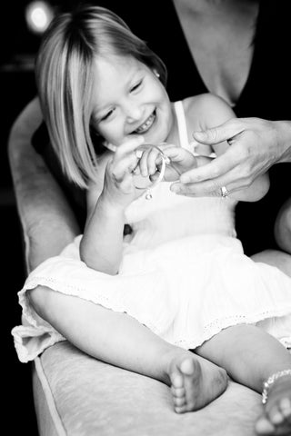 Little Girl smiling wearing bangle and jingle bell anklet.