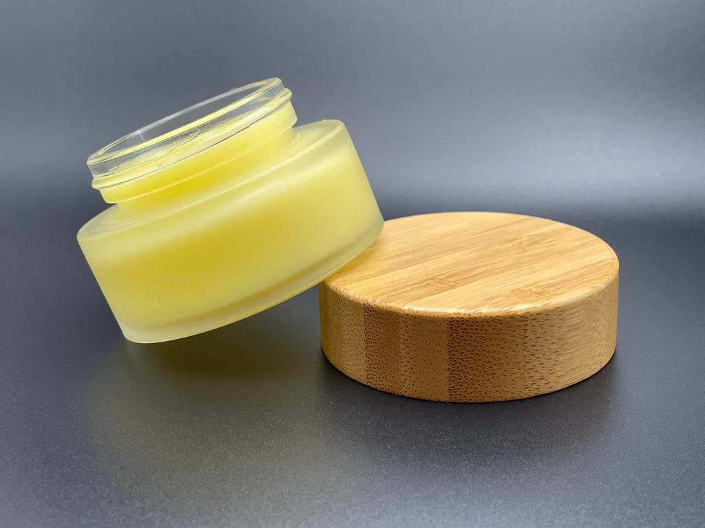 Sustainably packaged beeswax hand cream in frosted glass jar with aesthetic bamboo lid