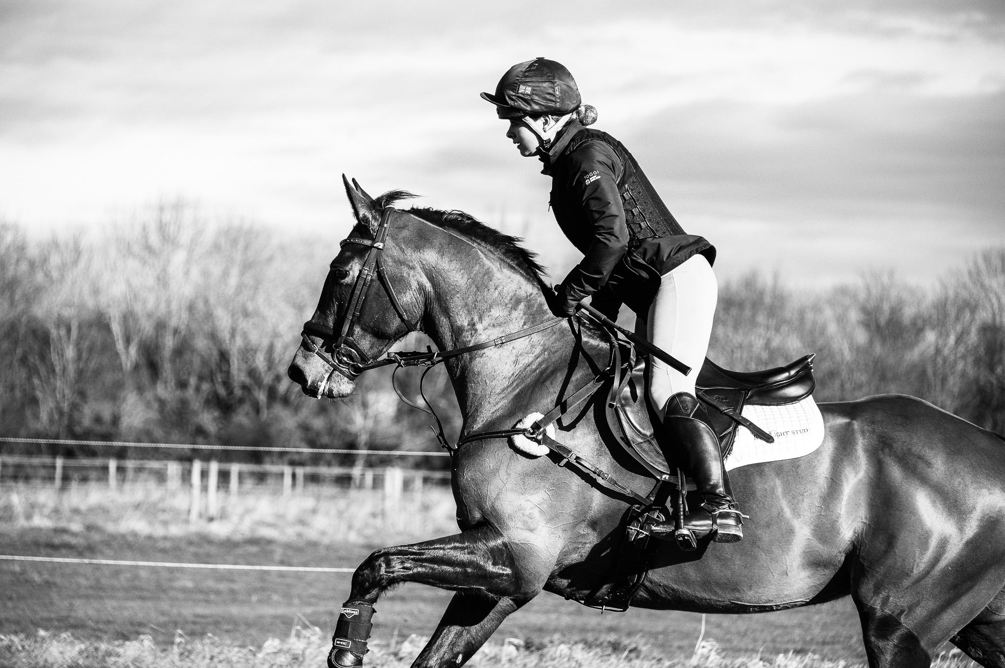 Equestrian out in the field - Horse rider and horse cantering during cross country.