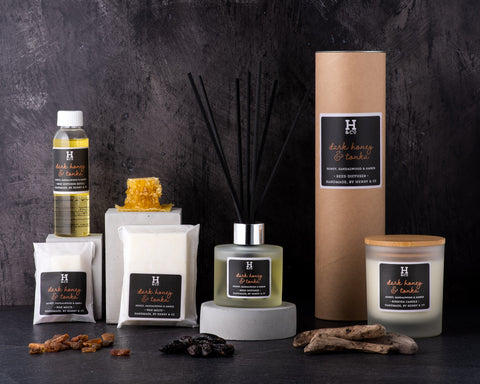 Henry & Co home fragrance Dark honey & tonka Collection, wax melts, reed diffusers, scented candles, reed diffuser refills surrounded by honey comb