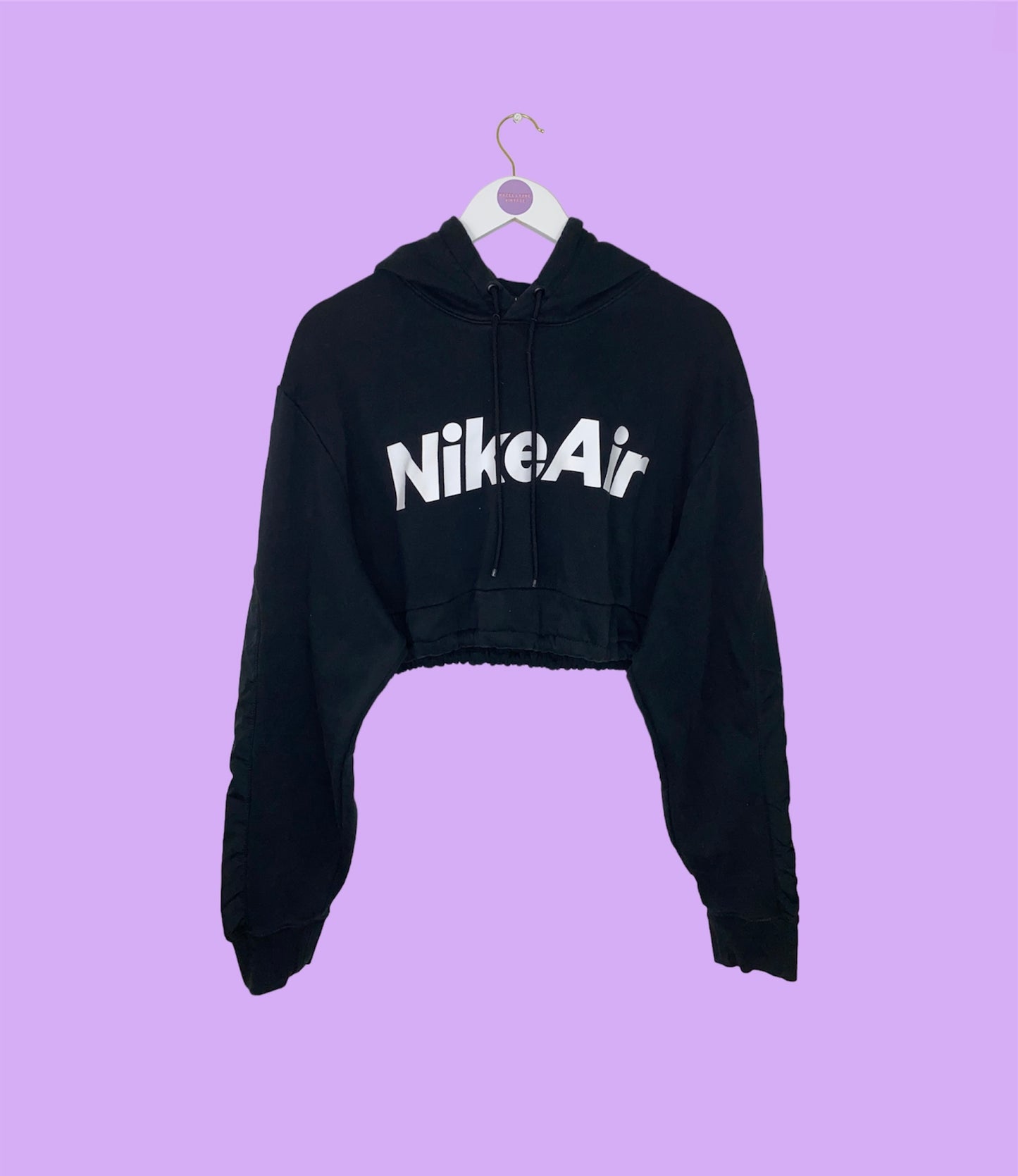 black cropped hoodie with white nike air logo shown on a lilac background