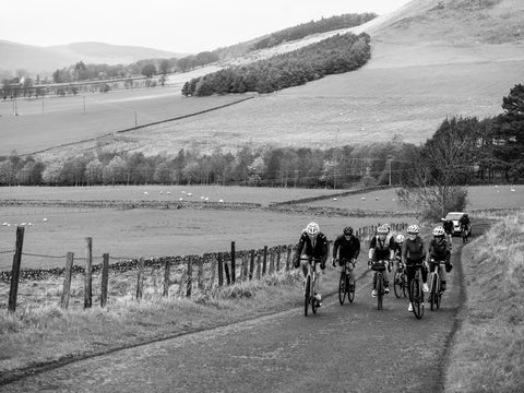 cyclists on country lane with mountains in background