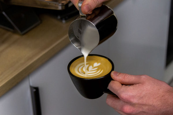 flat white being poured chimney fire coffee