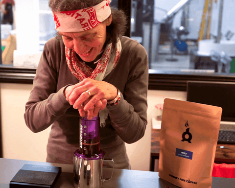 woman pushing down aeropress during brewing