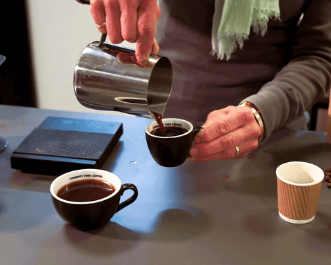 aeropress coffee being poured from a stainless steel jug