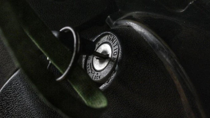 A close up of a black colored steering lock on a motorcycle