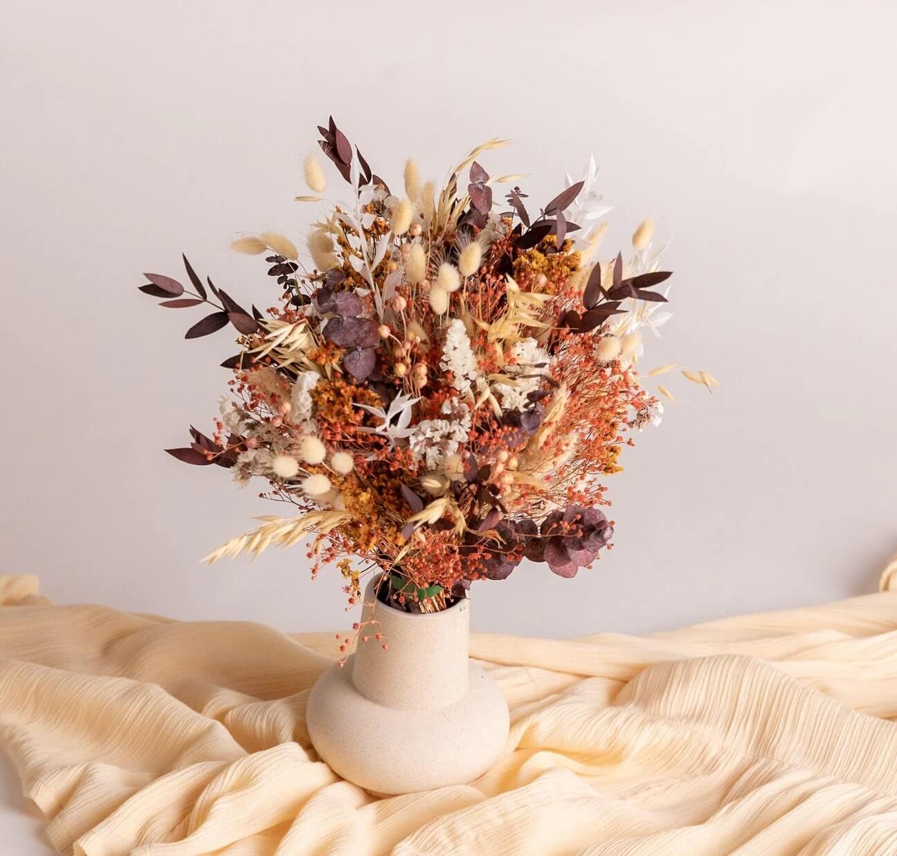 Dried Flowers bridal bouquet with burnt orange and cream flowers.