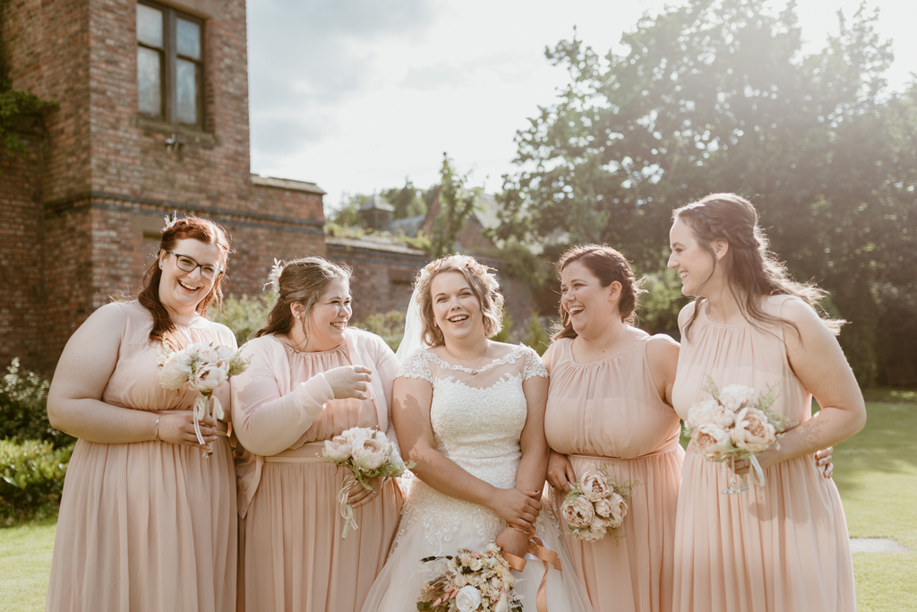 A beautiful bride and her bridesmaids stand together with their Hidden Botanics bouquets.