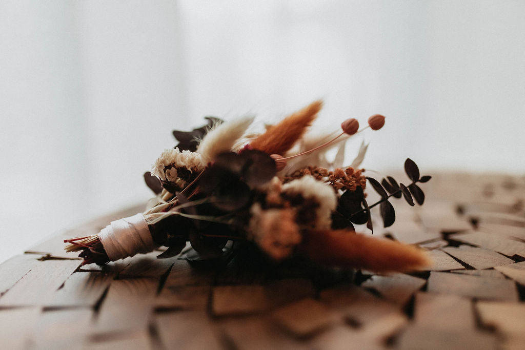 A small orange, white, and green dried flower bouquet from Hidden Botanics.