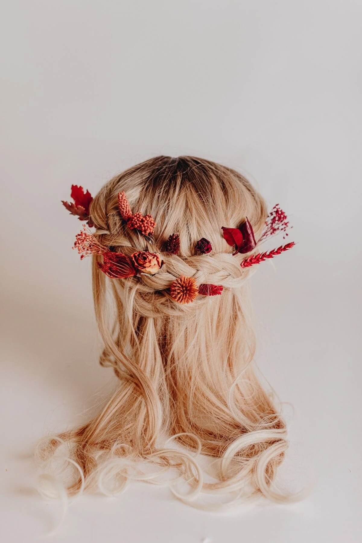 Hidden Botanics’ bohemian braided hair crown with red and orange wildflowers.