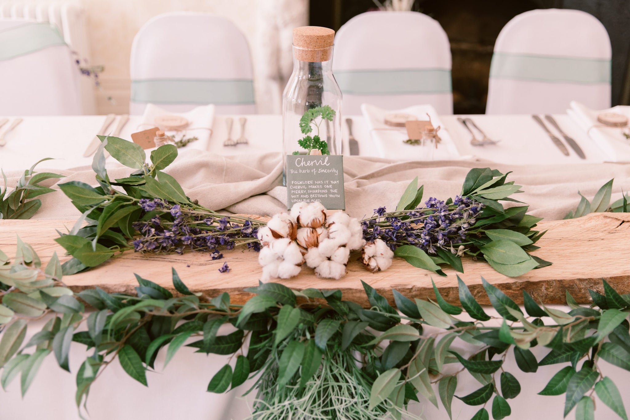 An elegant wedding table setting adorned with a Hidden Botanics garland, reflecting natural simplicity.