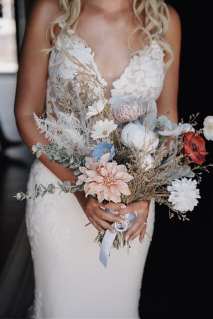 Bride holds a colorful dried flower bouquet from Hidden Botanics.