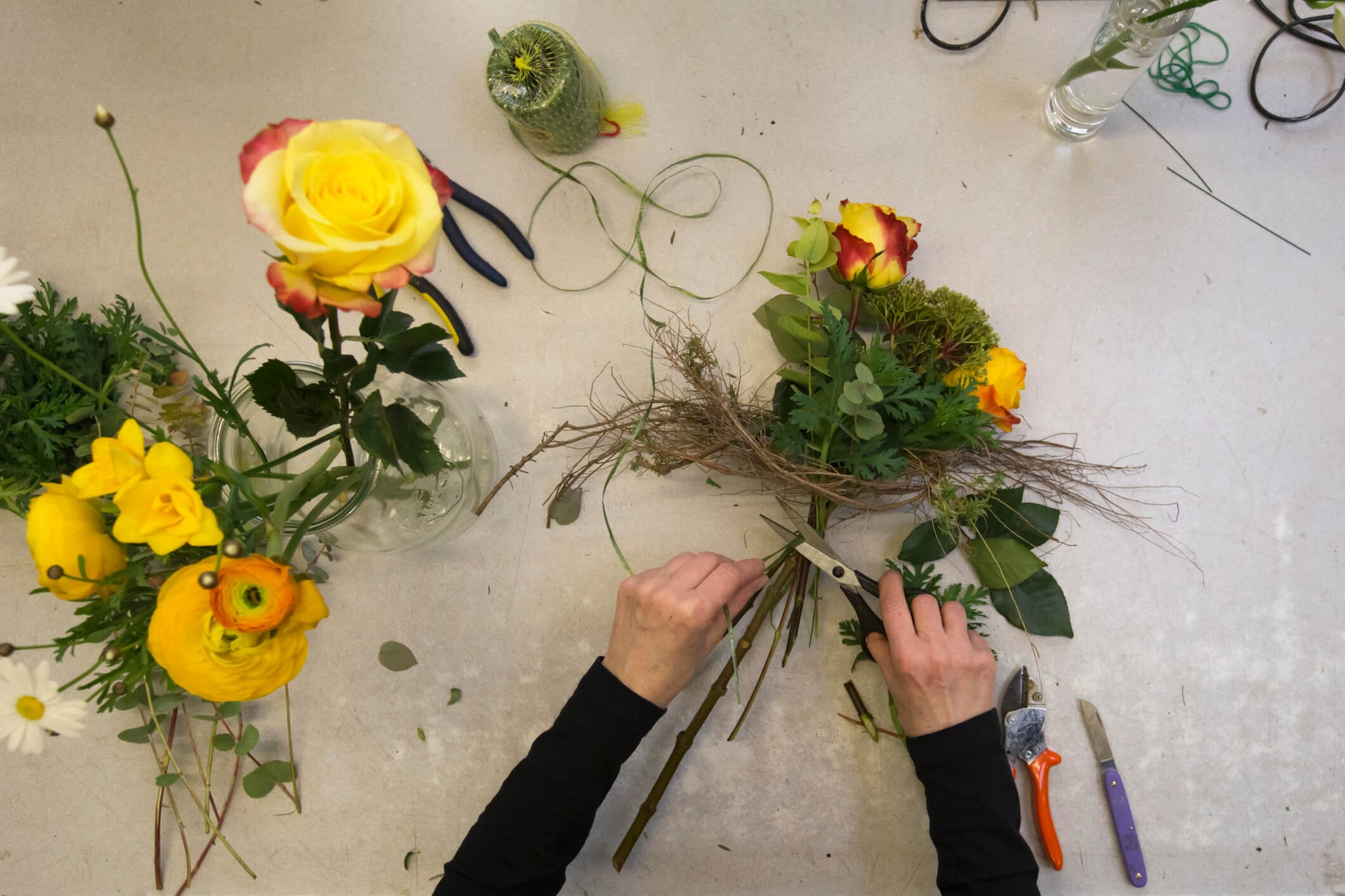 Person arranging flowers with the longest stem in the middle.
