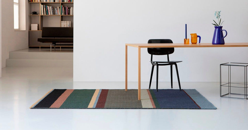 Designer rug placed under a table, showcasing its versatility