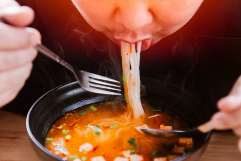 Man eating spicy noodles