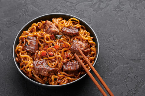 A bowl of chapaguri with chopsticks.