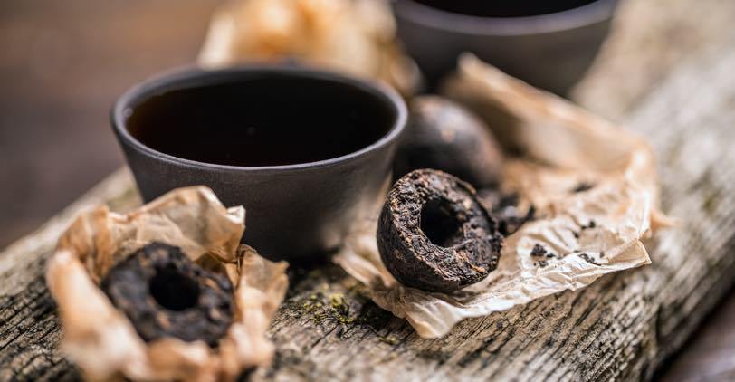 Fermented tea in cakes with a cup