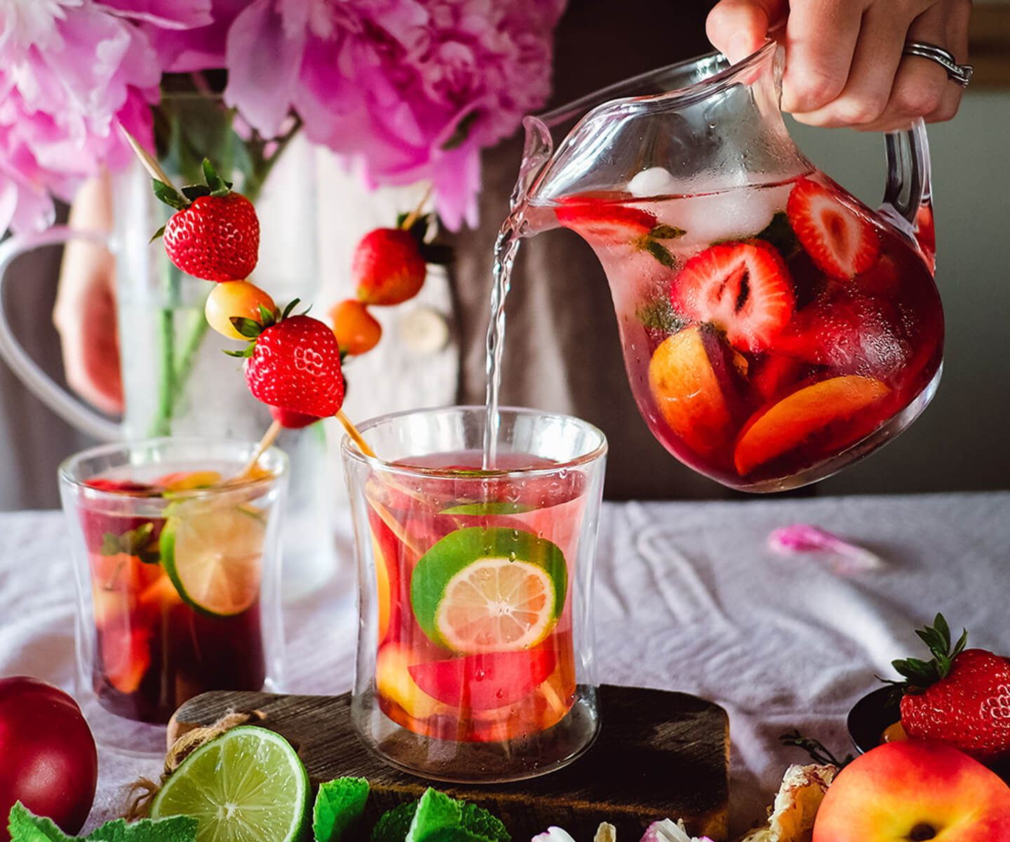 Serving refreshing iced tea with fresh fruit and herbs.