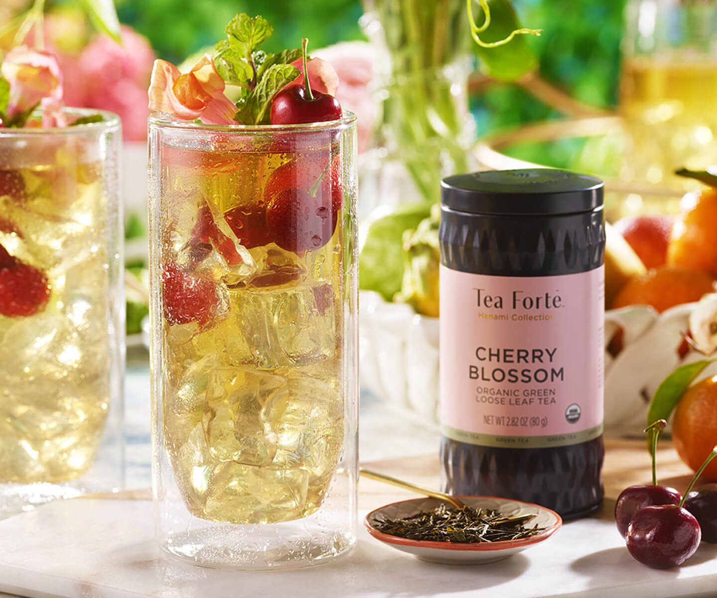 Cherry Blossom loose tea canister and a tall glass of iced tea with cherries.