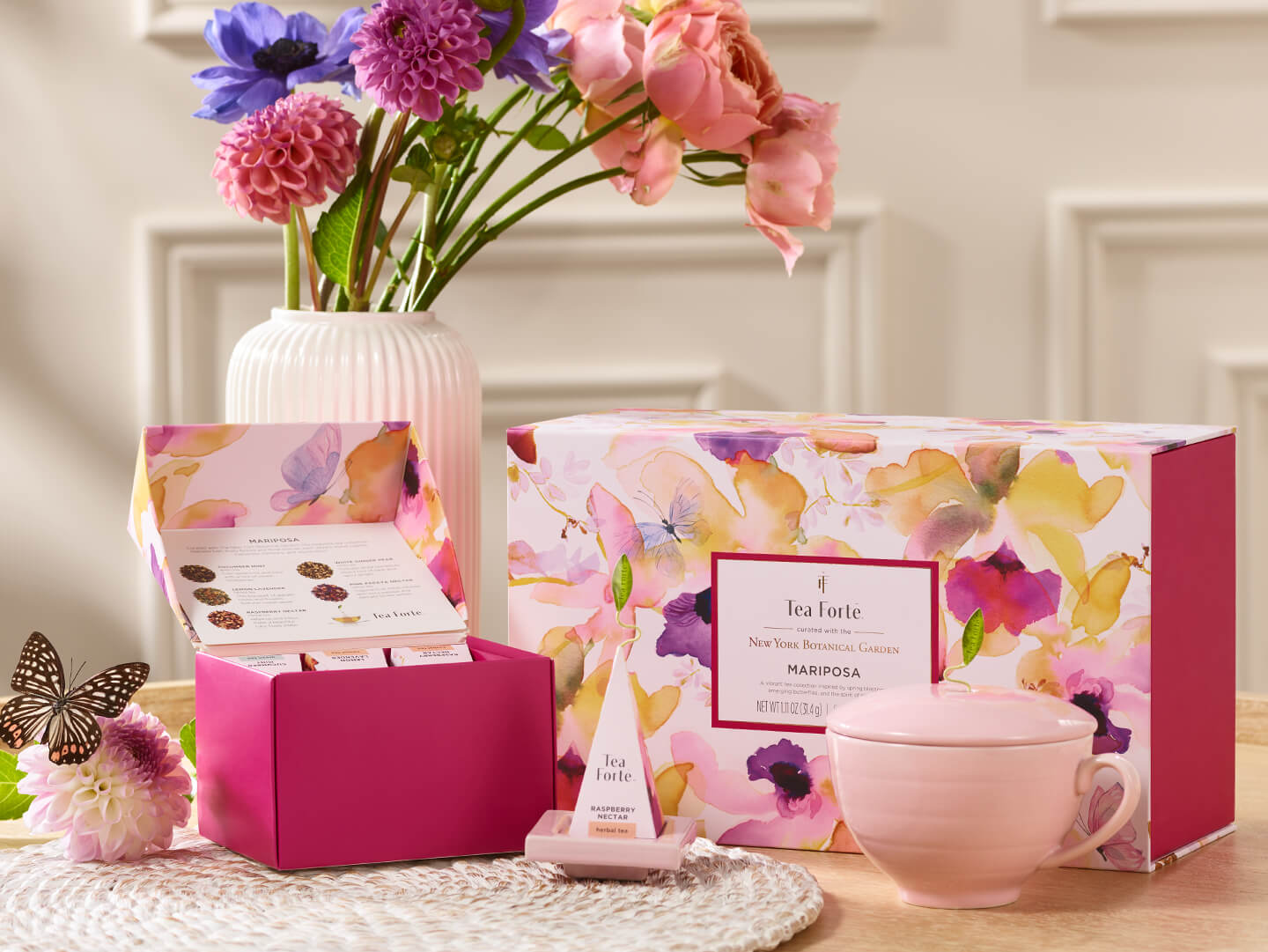 Mariposa Gift Set on a table with the box lid open, on a table with flowers and a butterfly.