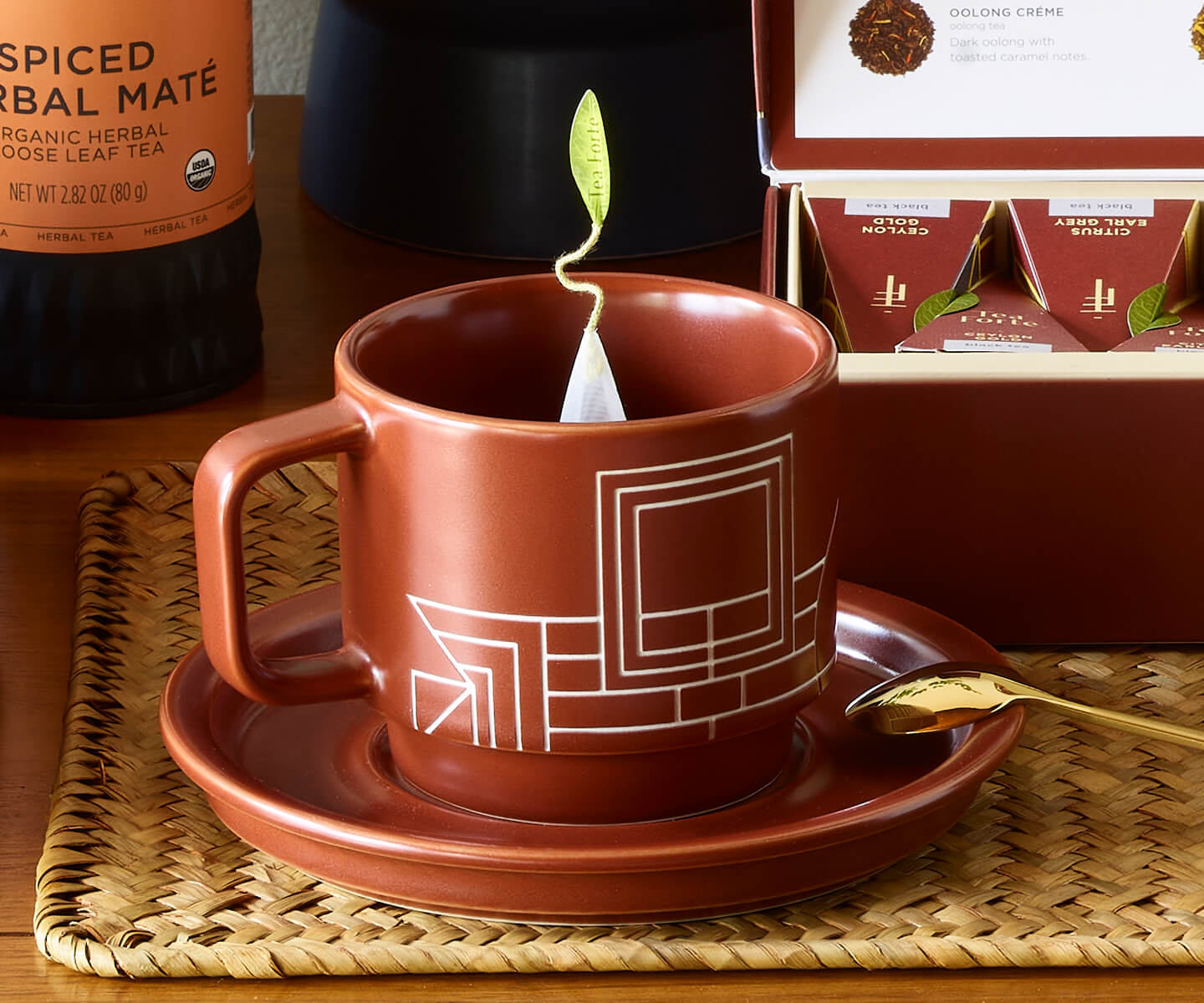 Diagram of Terra Teacup and Saucer on a wooden cabinet with pyramid tea infuser steeping inside