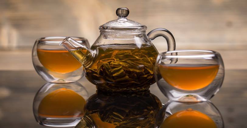 Tea brewing in a glass teapot and glass cups
