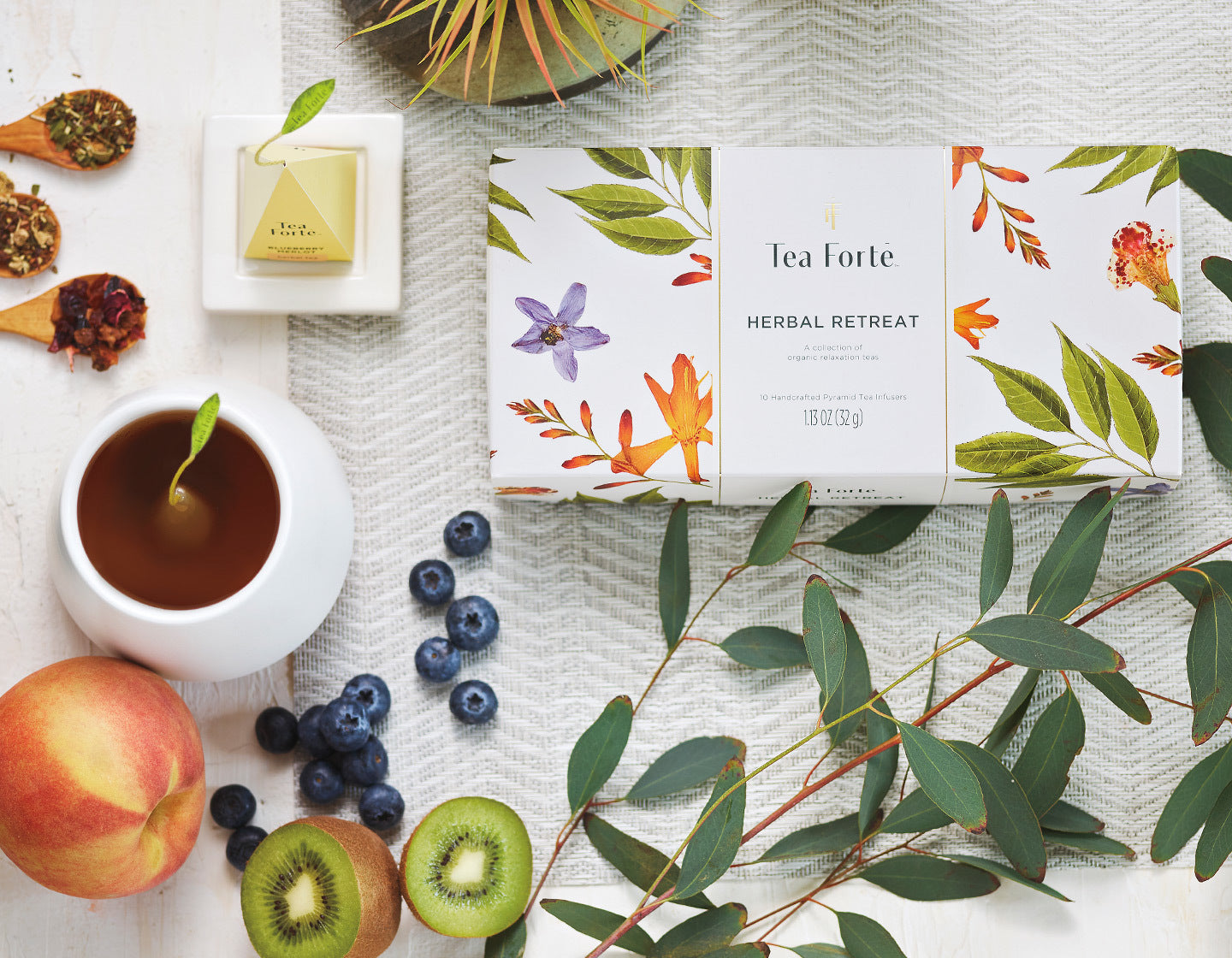 Herbal etreat presentation box with a cup of herbal tea and herbal tea ingredients surrounding it