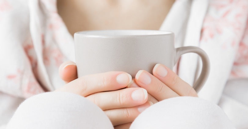 Holding a white cup of tea