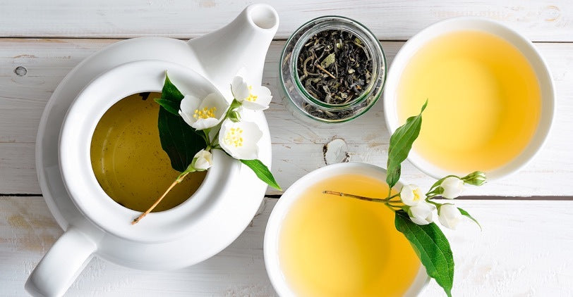 White teapot and cup of Jasmine tea from above