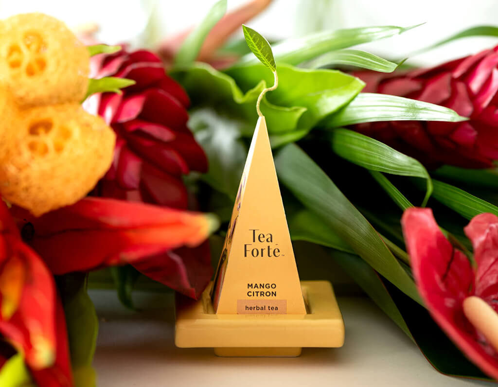 Mango Citron pyramid infuser on a tea tray with flowers behind