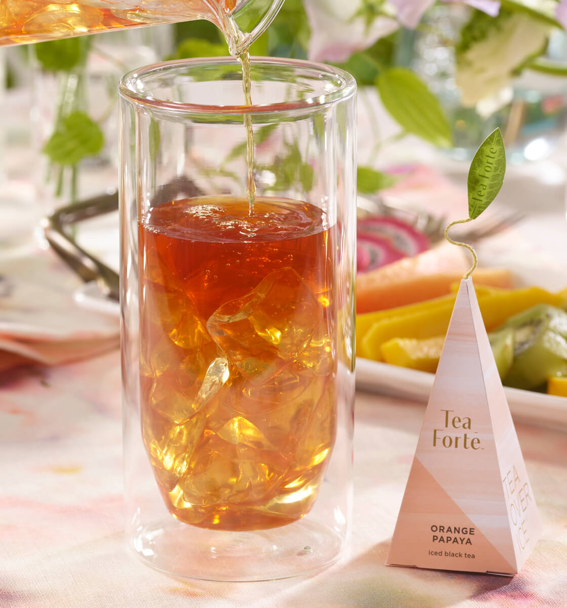 Orange Papaya iced tea infuser and glass of brewed tea being poured.