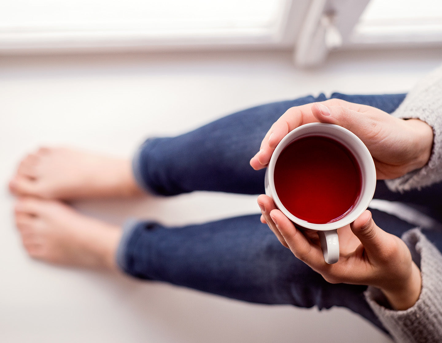 Holding a cup of rooibos tea in 2 hands