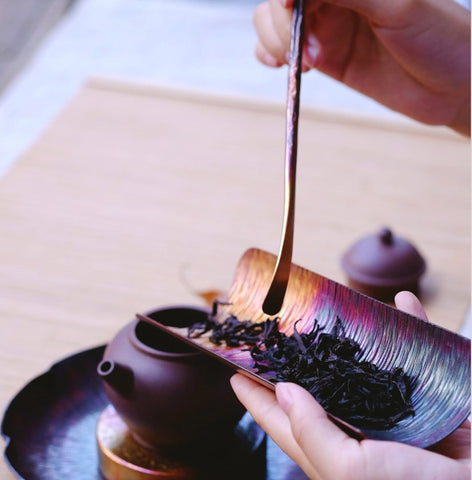 Loose tea leaves and tiny teapot