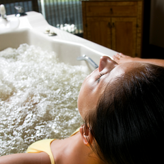 woman partaking in hydrotherapy with jetted bathtub