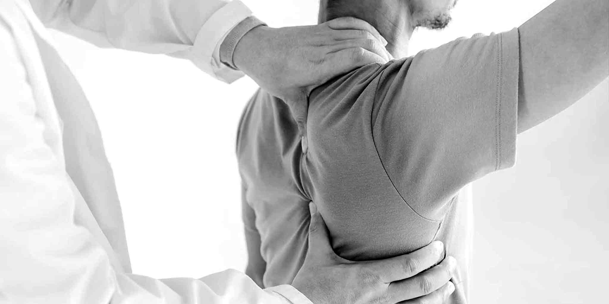 Therapist performing shoulder massage on male client at Core Benefits