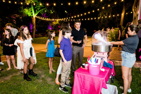 Guests enjoy freshly spun cotton candy at pink glitter disco Bat Mitzvah in Austin Texas