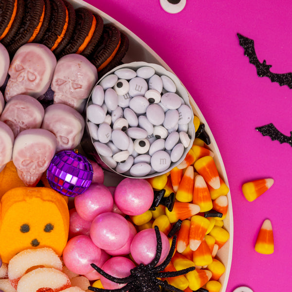 Close up of pink disco glitter Halloween Candy Board, showing M&Ms mixed with eyeball sprinkles