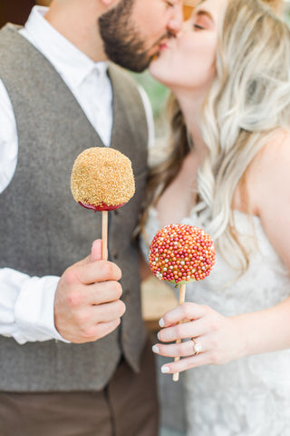 Bride and Groom celebrating their marriage with caramel apples - wedding dessert alternative