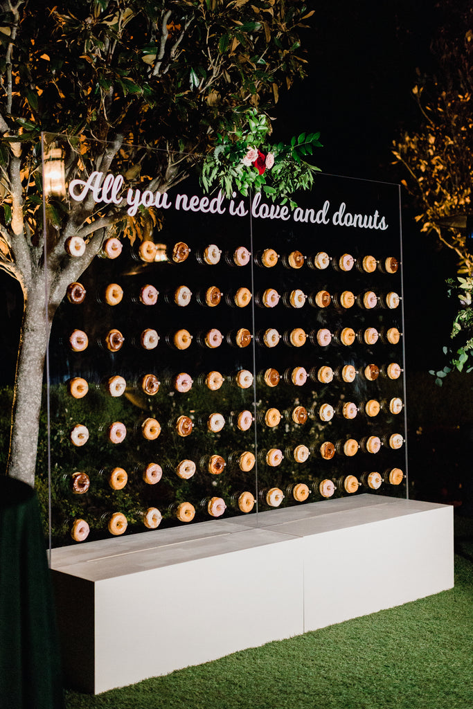 Custom wedding doughnut wall with "All you need is love and donuts"