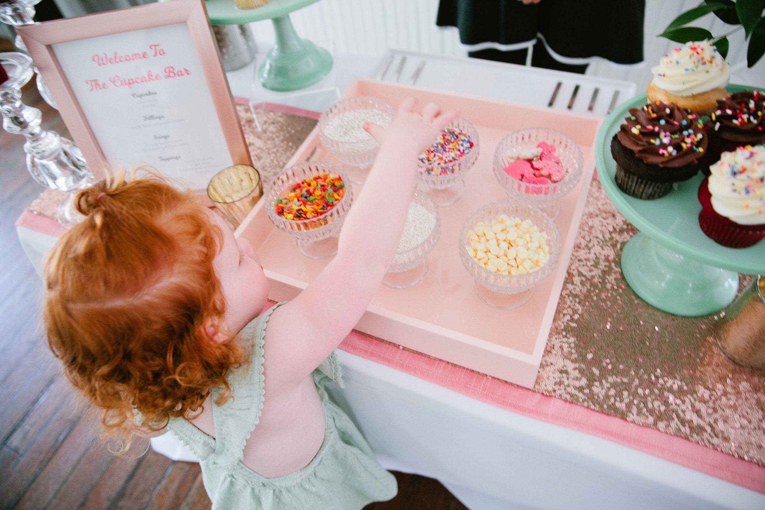 Little girl chooses cupcake from cupcake bar Austin Texas
