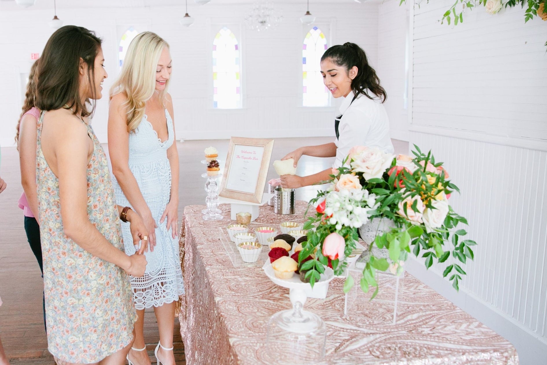 Woman serves custom cupcakes from Cupcake Bar to guests at wedding Austin Texas