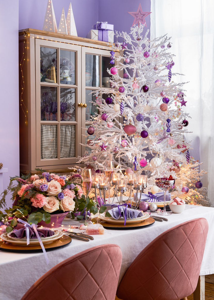 Fresh Lilac painted wall with a festive tablescape decoration and a white Christmas tree decorated with bright baubles and ornaments